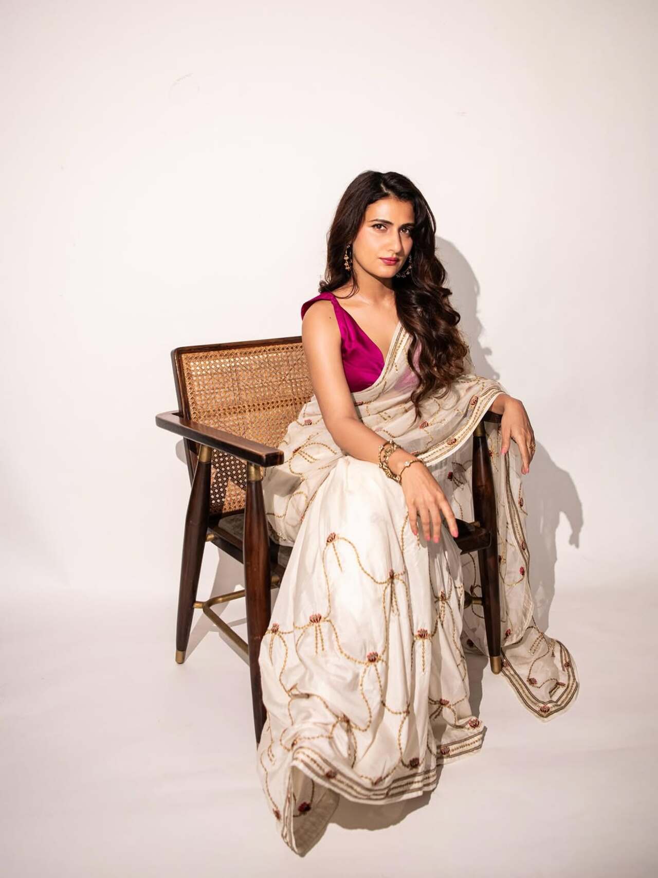 A combination of elegance and minimalism, she pairs this ivory saree with a fuchsia blouse, keeping the styling understated but regal